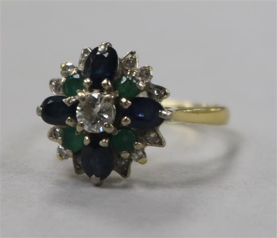 A 1970s 18ct gold, emerald, sapphire and diamond cluster ring, size M.